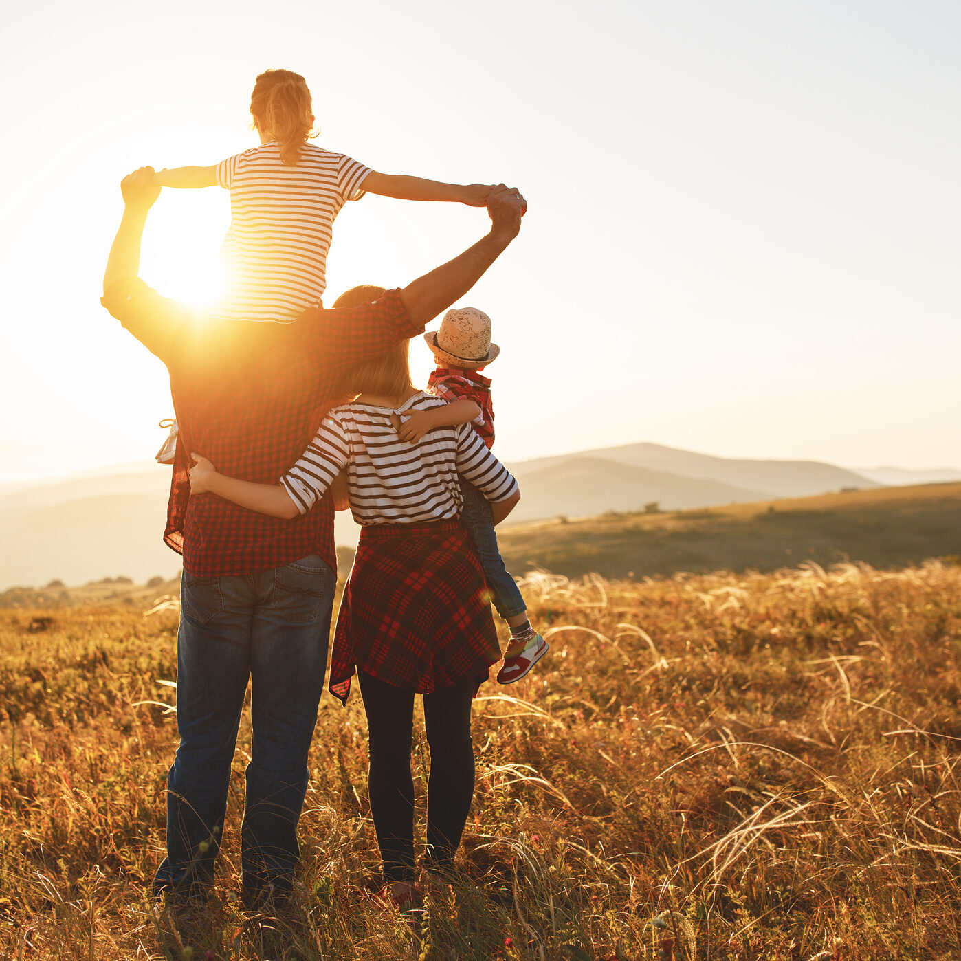 Happy family: mother, father, children son and daughter on sunset Happy family: mother, father, children son and daughter on nature on sunset